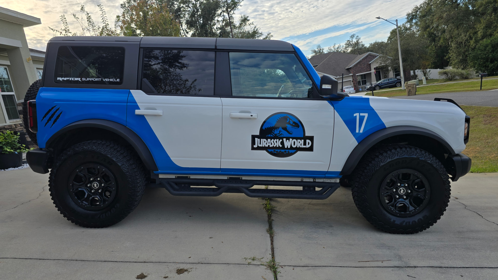 Passenger side profile of the wrapped Bronco Wildtrak in a driveway at dusk