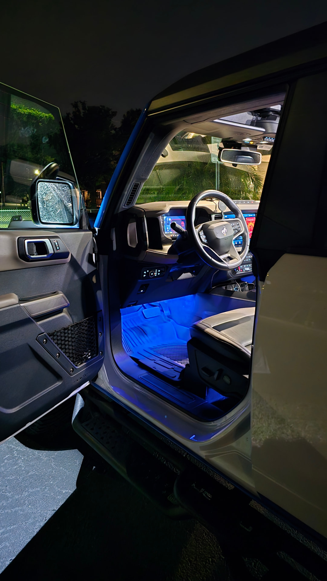 Custom blue LED interior lighting glowing in the footwells at night with the door open
