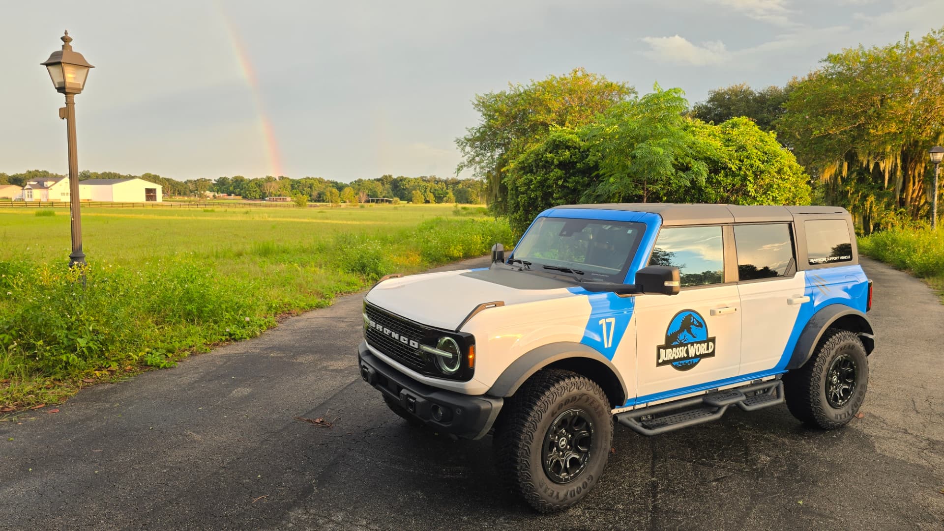 Bronco Wildtrak on a country drive with rainbow and pasture behind it
